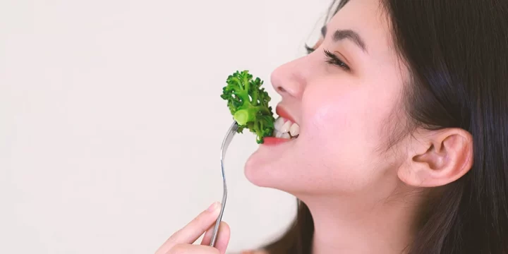 Close up shot of a person eating vegetables