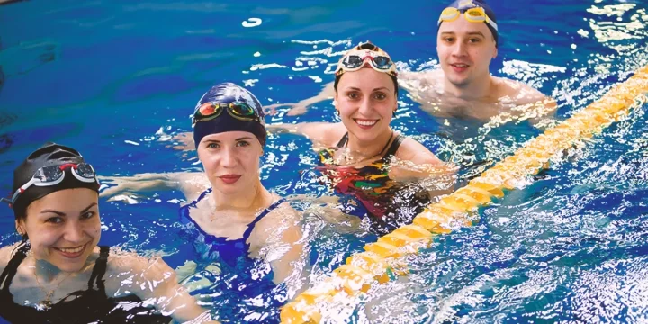 A row of women in an indoor pool
