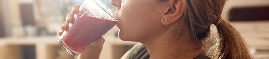 A woman drinking a smoothie