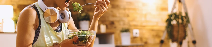 A person eating a salad in the living room