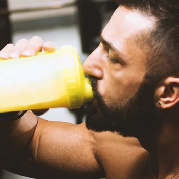 Close up shot of a bearded man drinking protein shake