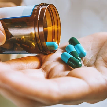 A person pouring pills from a bottle