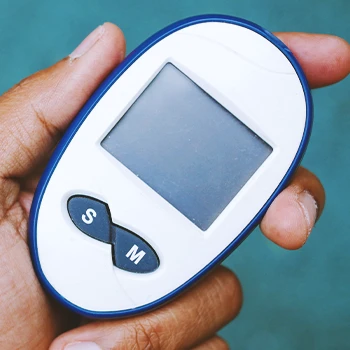 A person holding a blood sugar level monitor