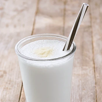 Close up shot of banana whey protein shake in a glass