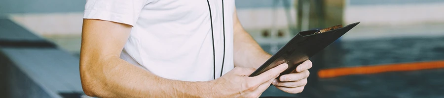 Close up shot of a gym trainer holding a clipboard