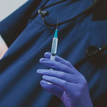 A person holding a syringe containing steroids