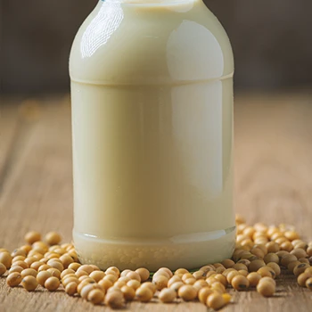 Soy milk inside a glass battle on a wooden table