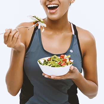 A healthy woman eating salad