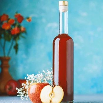 Apple vinegar in a tall bottle on a table