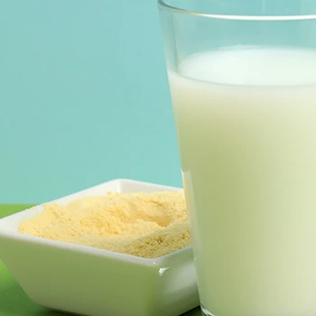 Glass of milk with a bowl of powder supplement