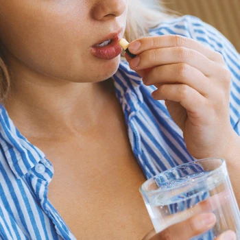 A woman taking in pills