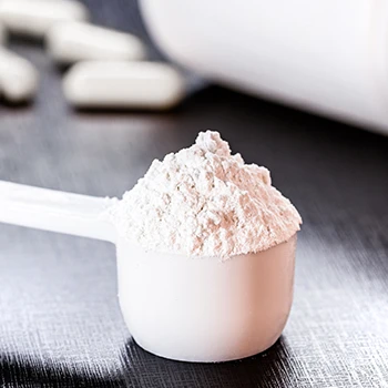 A close up shot of a scoop of supplement powder