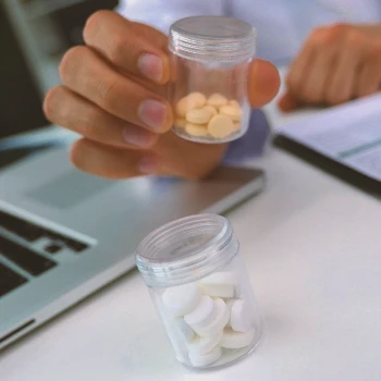 A person holding Clomid tablets on a table