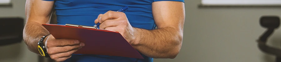 A gym coach holding a clipboard