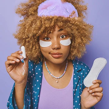 A woman on her period holding objects for menstruations