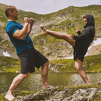 A coach training a mixed martial artist outside