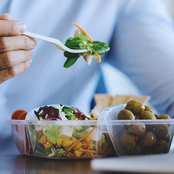 Close up shot of a person eating a variety of vegetables