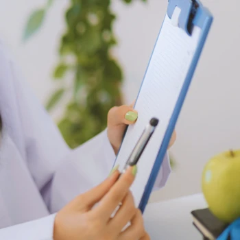 A doctor pointing to a clipboard