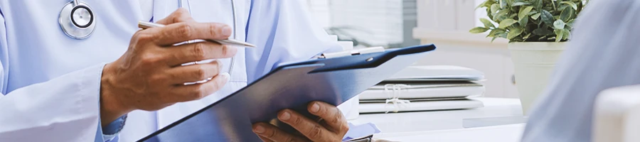 A doctor looking at a clipboard