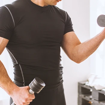 A person lifting a dumbbell at home