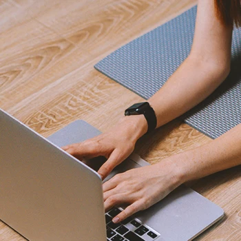 A person on a yoga mat using a laptop