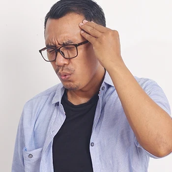 A stressed man wearing eyeglasses