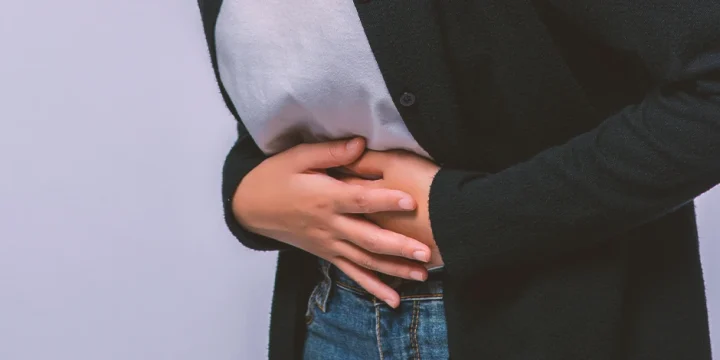 A woman holding her groin in pain