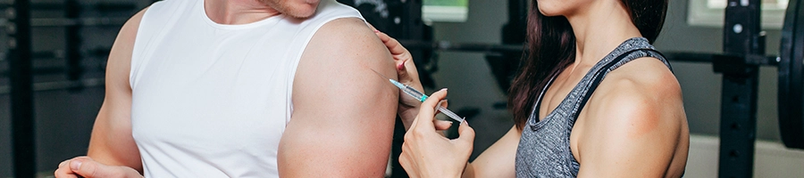 A woman injecting a testosterone syringe on a person