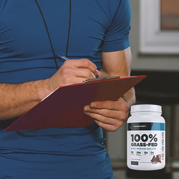 A gym coach writing down notes on a clipboard with Transparent Labs Whey Protein on the foreground