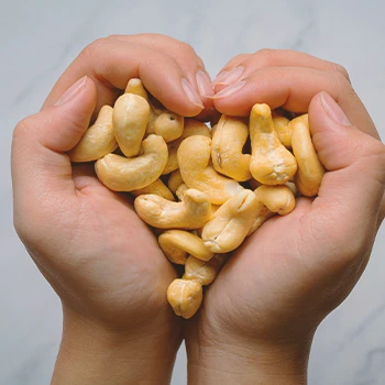 A person holding a bunch of cashews to increase testosterone