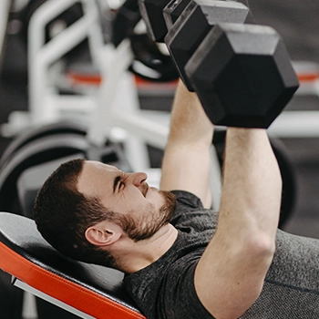 A man holding dumbbells in gym