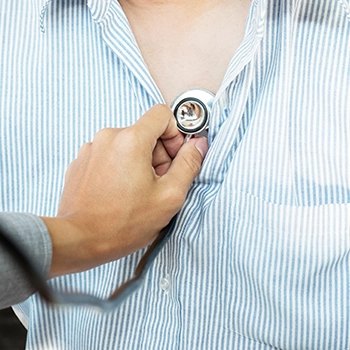 Doctor using stethoscope to check up patient