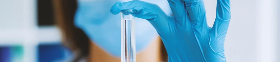 A chemist holding up a glass vial