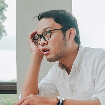 A stressed man wearing glass