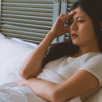 A woman with low testosterone lost in thought in bed