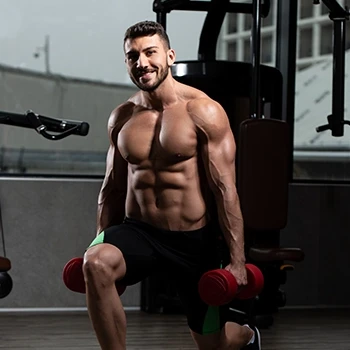 A muscular man lifting dumbbells at the gym