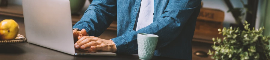 A person using a laptop inside a kitchen