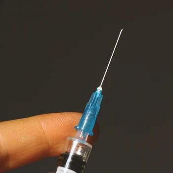 Close up shot of a person holding a steroid syringe