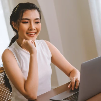 A woman looking at a laptop at home