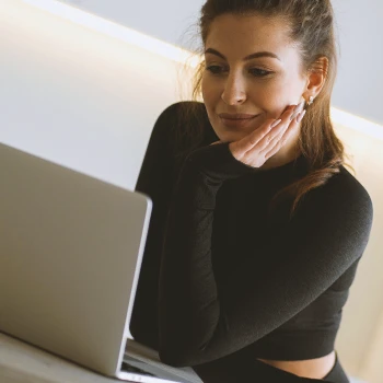 A woman using a laptop at the kitchen