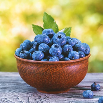 Close up shot of blueberries on a wooden bowl