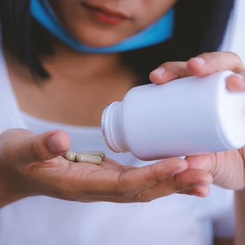 Close up shot of a person pouring pills on her hand