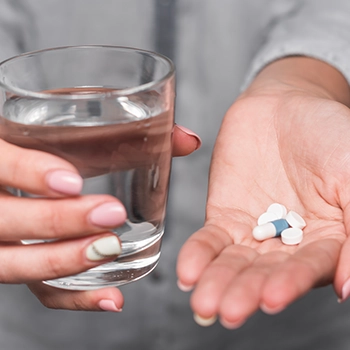 Holding supplements and multivitamins with a glass of water