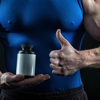 Holding supplement container while giving thumbs up