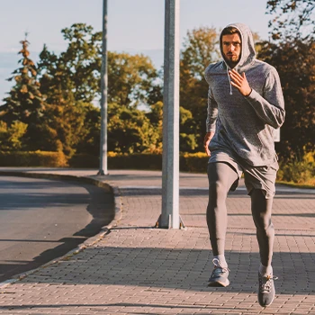 A male athlete jogging at the park outside