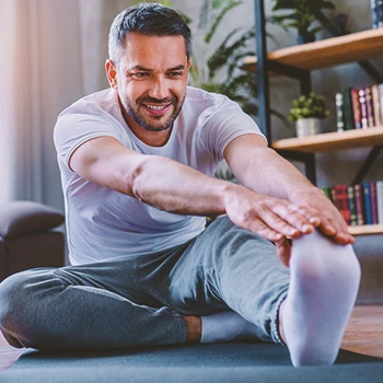 A person stretching at the floor indoors