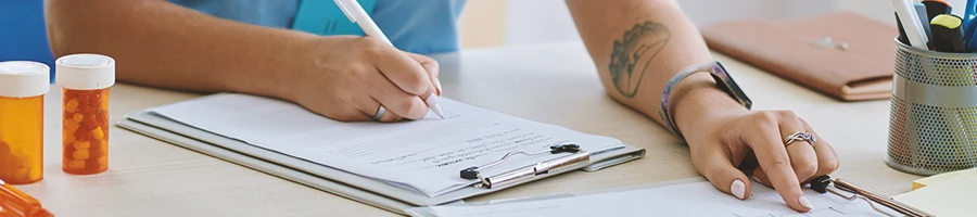 A nurse planning out a supplement stack on a clipboard