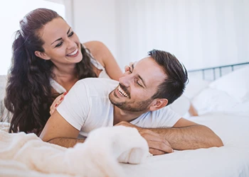 A couple cuddling happily in bed