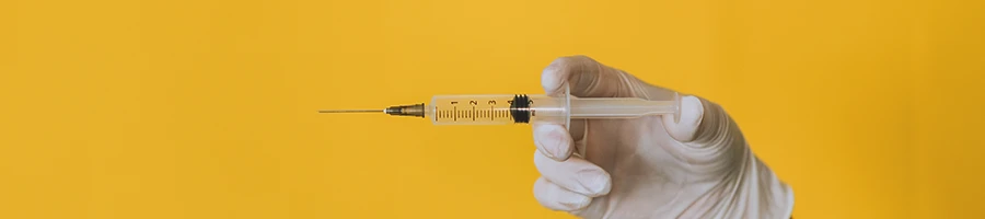 A doctor holding a syringe of testosterone cypionate