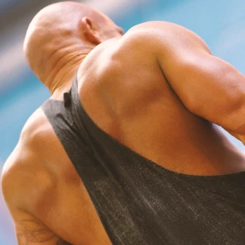 A bald man flexing his back